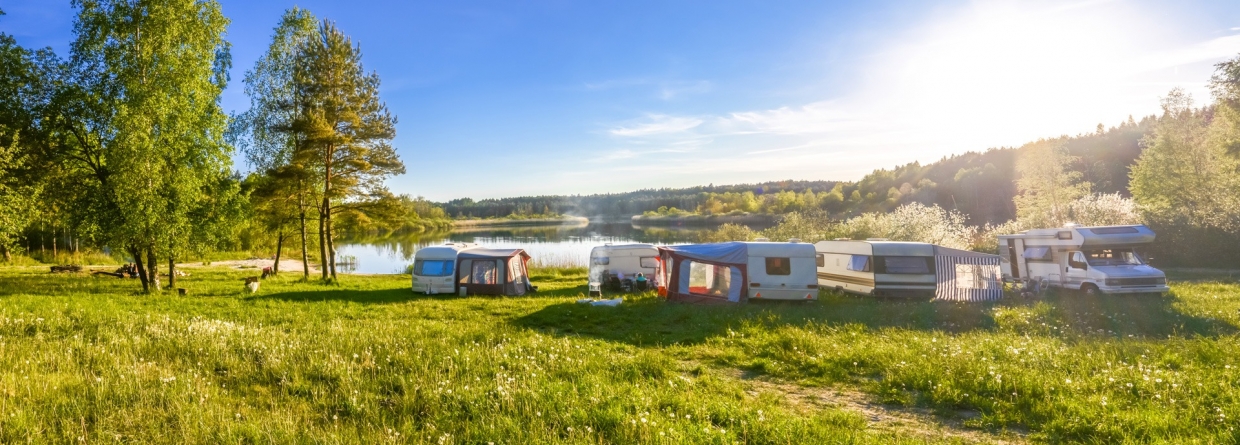 familie vakantie op een camping met caravans en campers rondom een meer