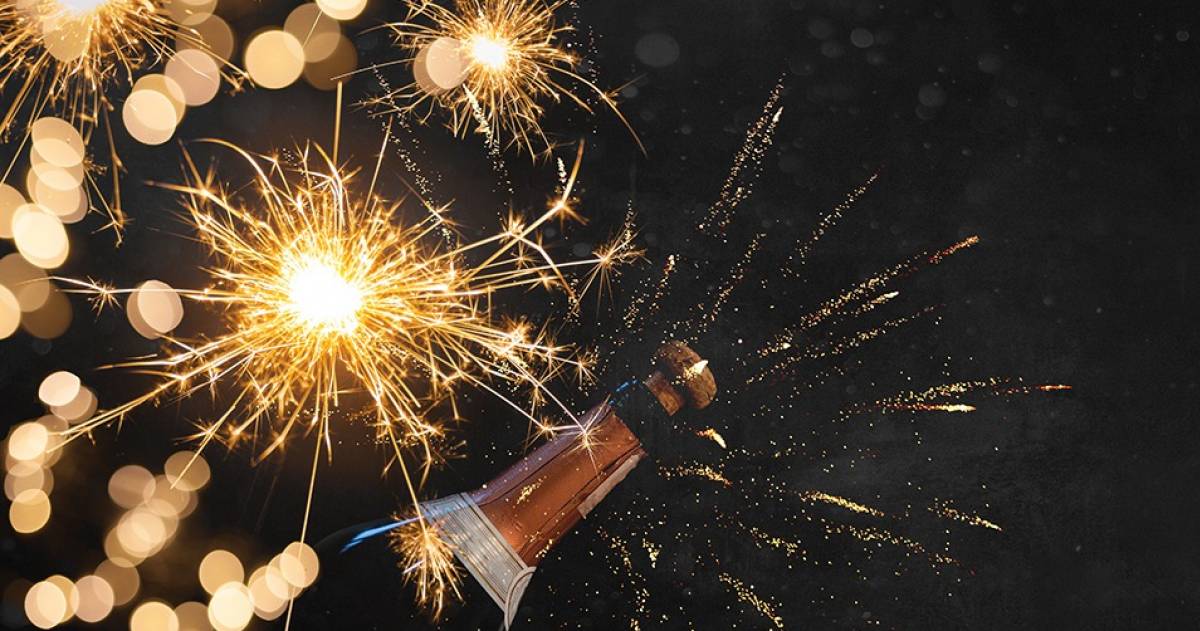 Oud en nieuw, champagnefles met vuurwerk in de lucht