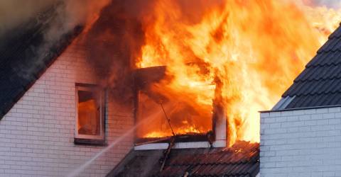 Vlammen uit het raam van een woning