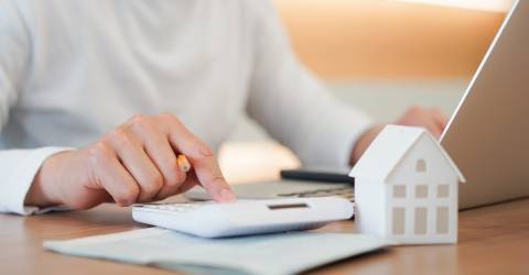 man berekent met een calculator de kosten voor zijn hypotheek